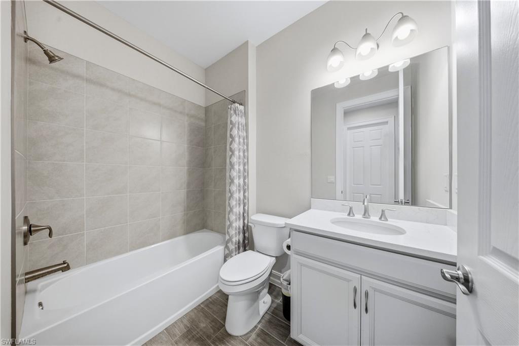 1059 Enbrook Loop Naples, FL 34114 - Photo 22 of 40 Full bath featuring vanity, shower / bath combo, and wood finish floors
