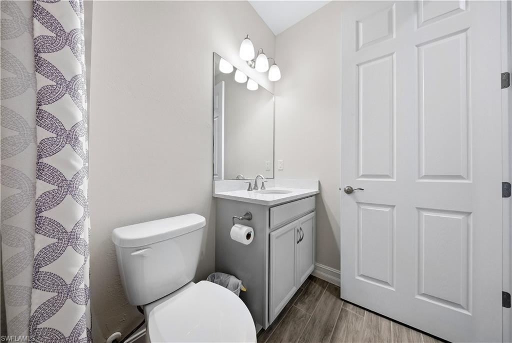 1059 Enbrook Loop Naples, FL 34114 - Photo 23 of 40 Full bath featuring vanity, wood tiled floors, and a shower with shower curtain