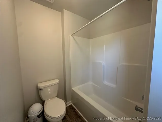 a white toilet sitting next to a bath tub