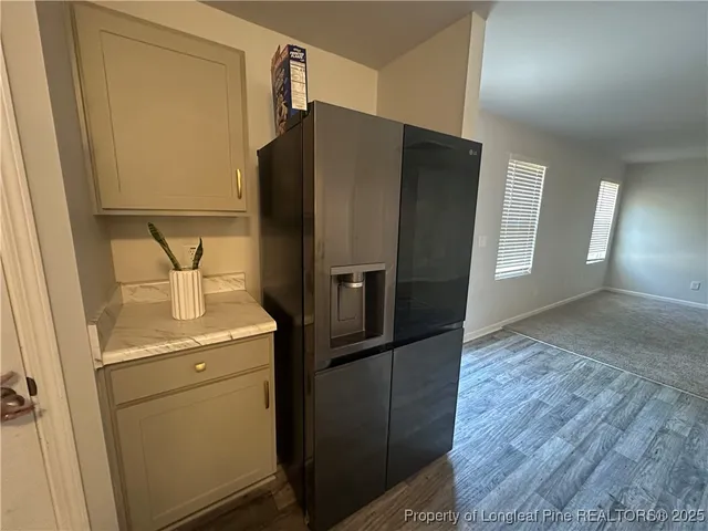 a metallic refrigerator freezer sitting in a kitchen