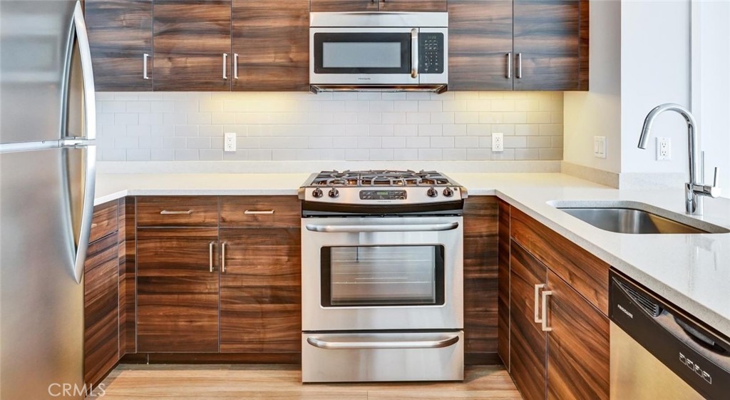 100 Van Ness Avenue, Unit 402 San Francisco, CA 94102 - Photo 3 of 75 a kitchen with granite countertop a stove top oven microwave and cabinets