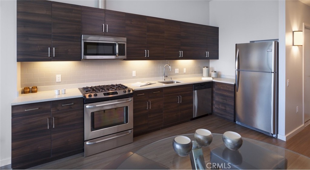 100 Van Ness Avenue, Unit 402 San Francisco, CA 94102 - Photo 4 of 75 a kitchen with stainless steel appliances granite countertop a stove a sink and a microwave