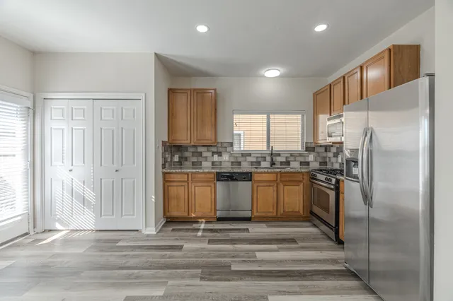 a kitchen with stainless steel appliances granite countertop a refrigerator sink and cabinets