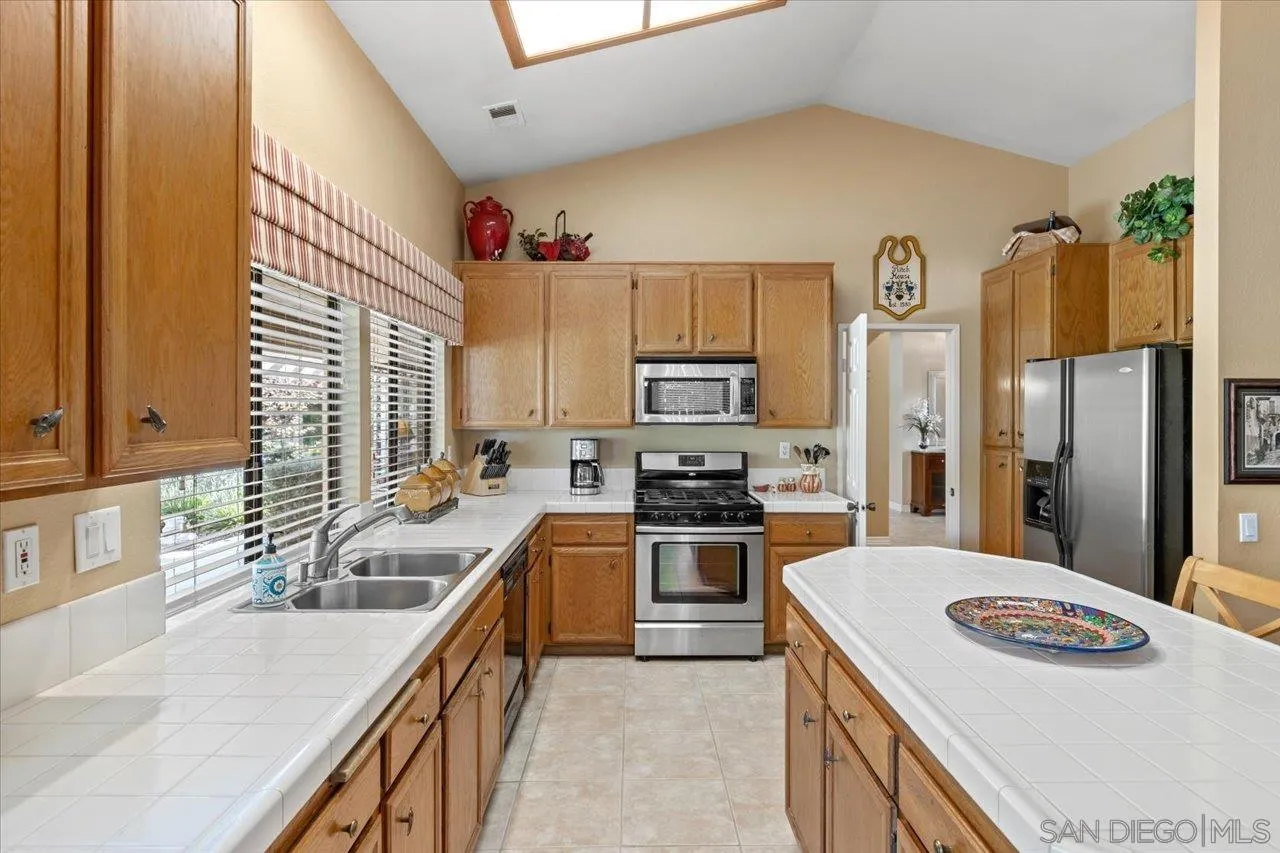 1787 Wolverine Way Vista, CA 92084 - Photo 12 of 35 a kitchen with stainless steel appliances granite countertop a sink stove and refrigerator