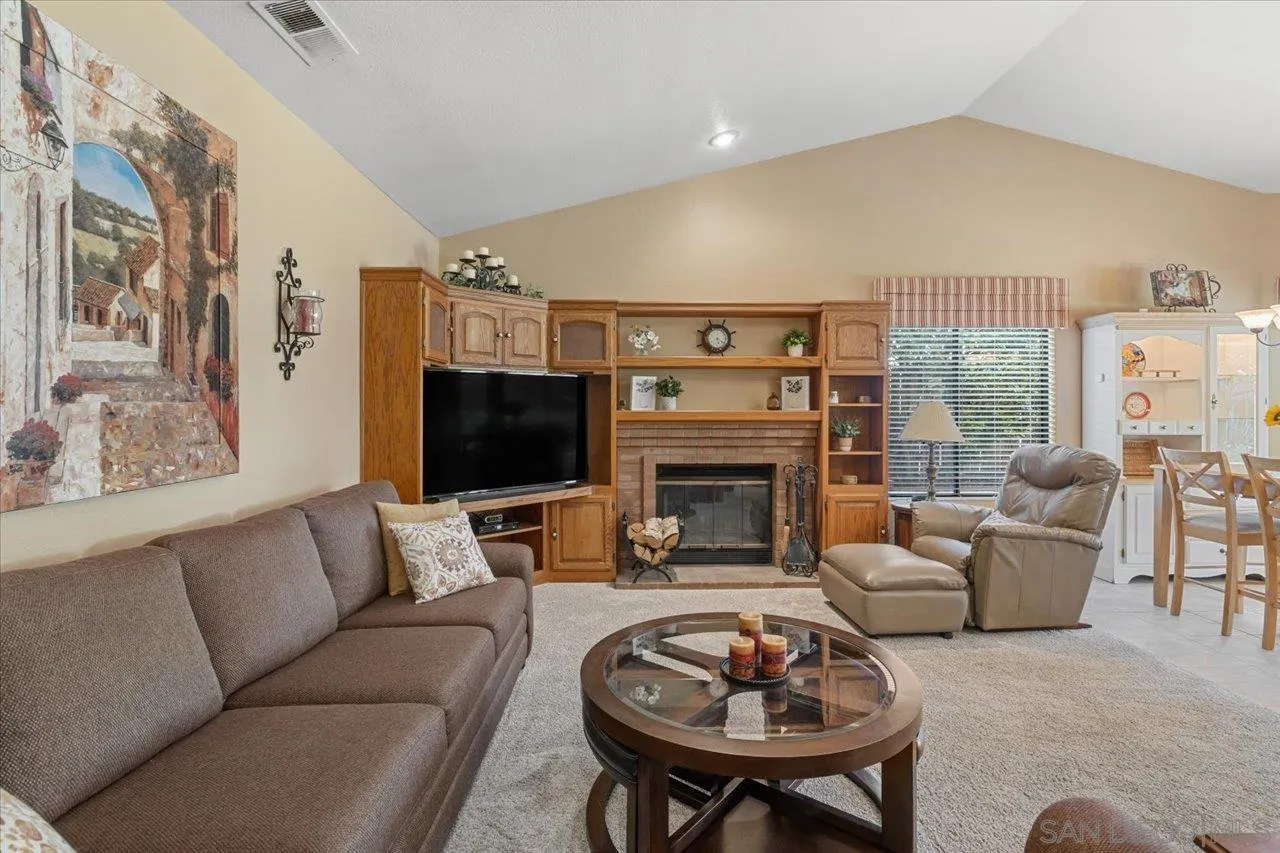 1787 Wolverine Way Vista, CA 92084 - Photo 14 of 35 a living room with furniture a flat screen tv and a fireplace