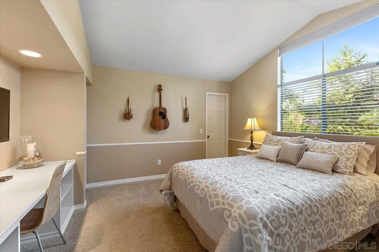 1787 Wolverine Way Vista, CA 92084 - Photo 22 of 35 a bedroom with a large bed and a table