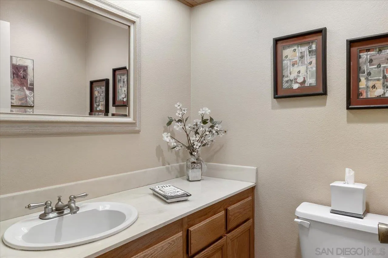 1787 Wolverine Way Vista, CA 92084 - Photo 25 of 35 a bathroom with a toilet sink and mirror