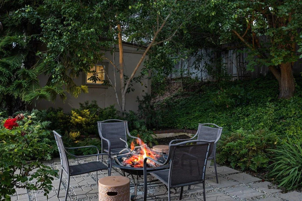 1787 Wolverine Way Vista, CA 92084 - Photo 29 of 35 a backyard of a house with table and chairs potted plants and a bench