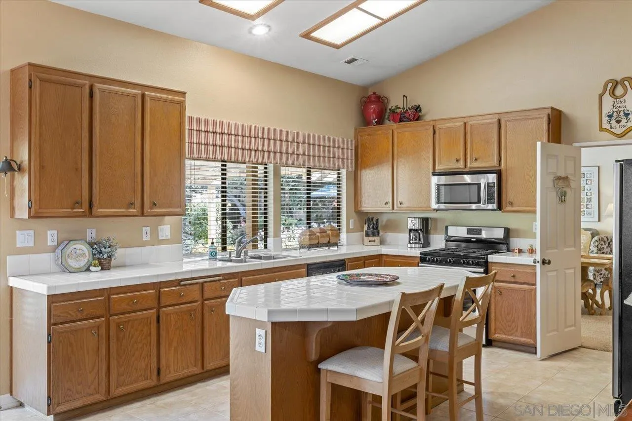1787 Wolverine Way Vista, CA 92084 - Photo 10 of 35 a kitchen with a sink stove and cabinets