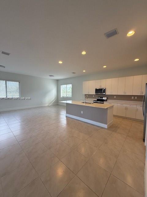 4957 Gambero Way Ave Maria, FL 34142 - Photo 6 of 34 a open kitchen with kitchen island white cabinets and stainless steel appliances