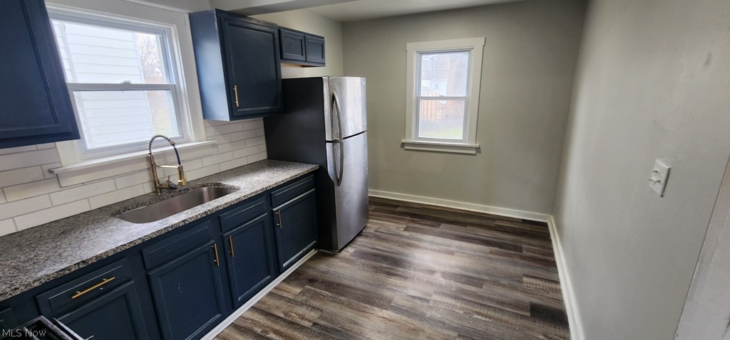 1514 Clermont Road Cleveland, OH 44110 - Photo 5 of 16 Kitchen featuring tasteful backsplash, dark wood-type flooring, freestanding refrigerator, blue cabinetry, and plenty of natural light