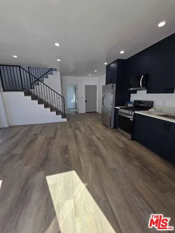 a large kitchen with stainless steel appliances a large counter top