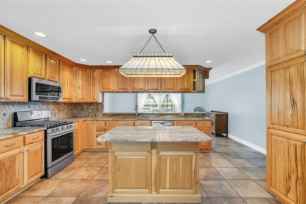 4147 Boggy Creek Road Kissimmee, FL 34744 - Photo 11 of 49 a kitchen with granite countertop a sink stove and cabinets
