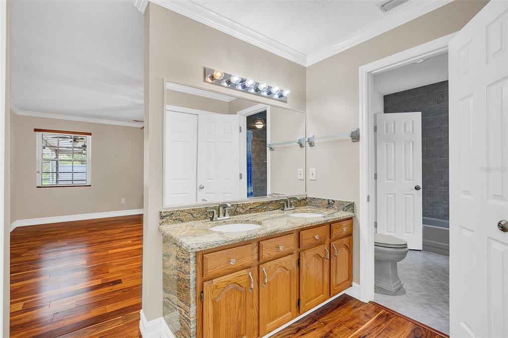 4147 Boggy Creek Road Kissimmee, FL 34744 - Photo 15 of 49 a bathroom with a granite countertop sink a mirror and a shower