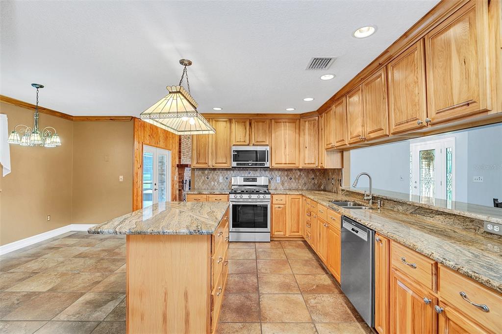 4147 Boggy Creek Road Kissimmee, FL 34744 - Photo 3 of 49 a kitchen with stainless steel appliances granite countertop a stove sink and cabinets