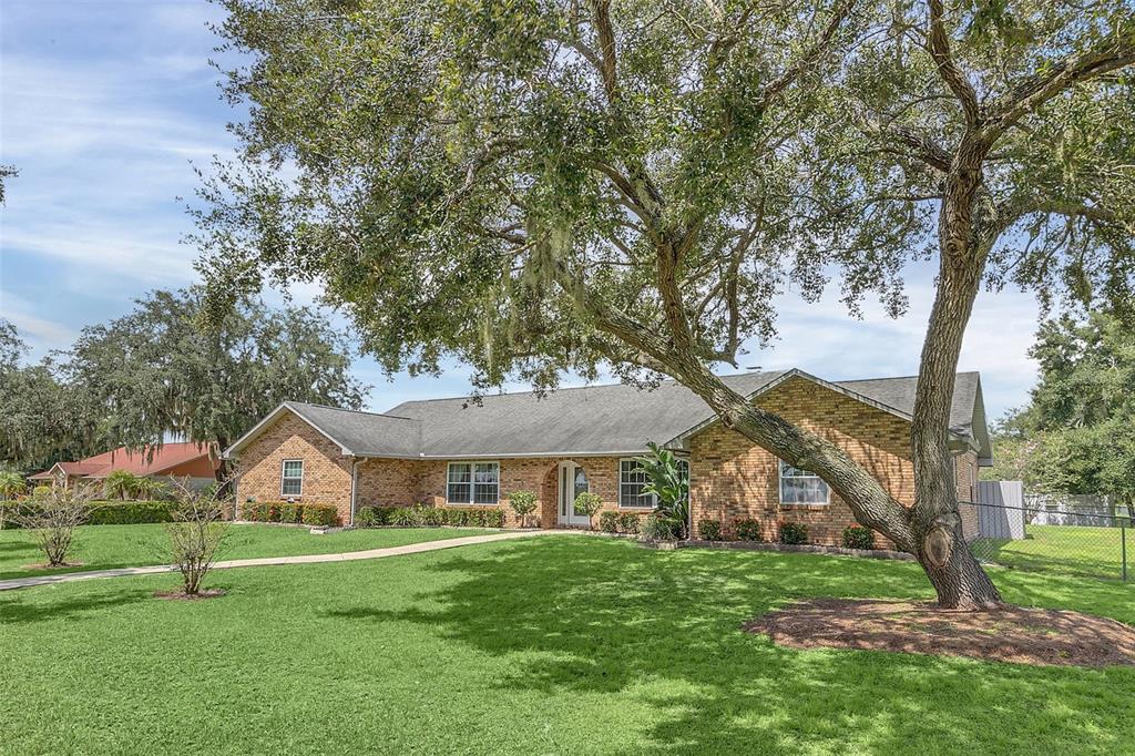 4147 Boggy Creek Road Kissimmee, FL 34744 - Photo 46 of 49 a front view of a house with a garden and trees