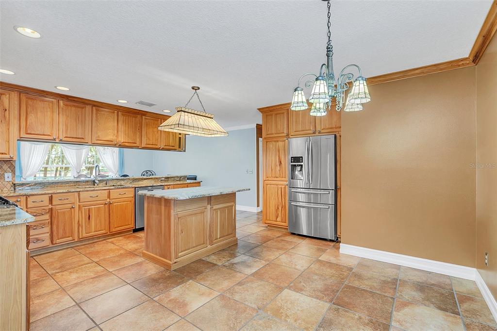 4147 Boggy Creek Road Kissimmee, FL 34744 - Photo 9 of 49 a kitchen with stainless steel appliances granite countertop a sink a stove a refrigerator cabinets and a window