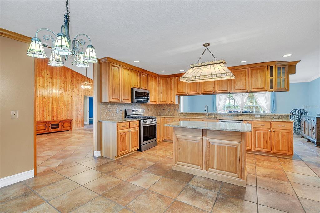 4147 Boggy Creek Road Kissimmee, FL 34744 - Photo 10 of 49 a kitchen with stainless steel appliances granite countertop a stove a sink a oven a counter top space cabinets and a dining table
