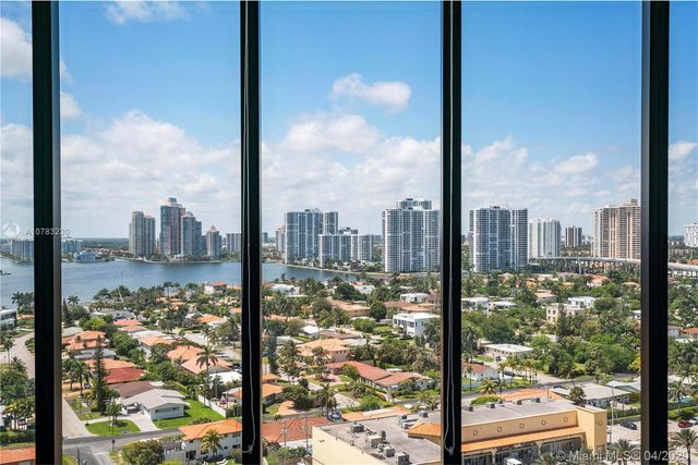 a view of a livingroom with furniture water view and large windows