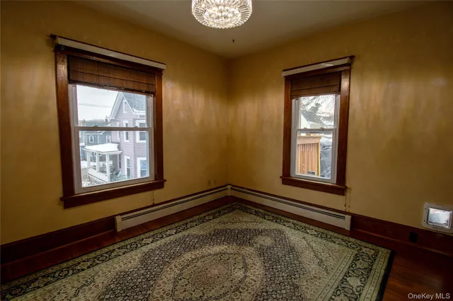 a view of a hallway with wooden floor and a living room