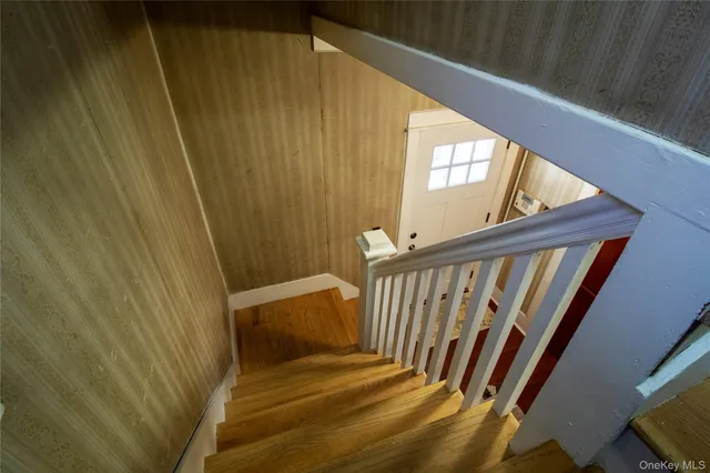 a view of an empty room with a window and a dresser
