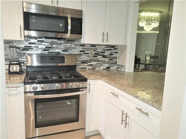 a kitchen with granite countertop a stove and a microwave