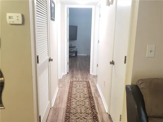 a view of a hallway with a livingroom and a bathroom