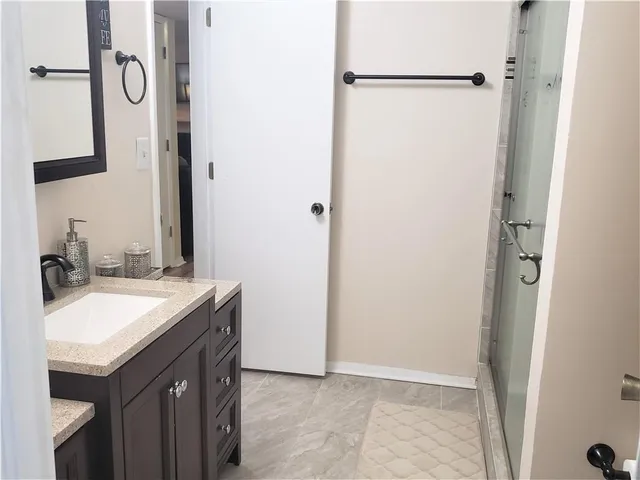 a bathroom with a granite countertop sink shower and a mirror
