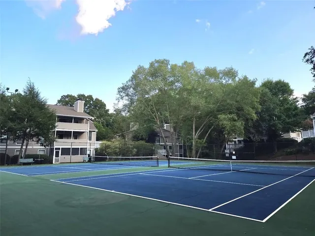 a view of a tennis ground with trees in the background
