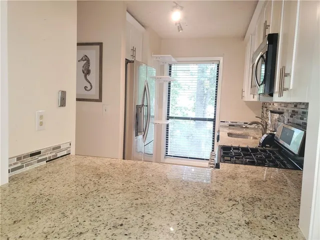 a view of a livingroom with wooden floor and a fireplace