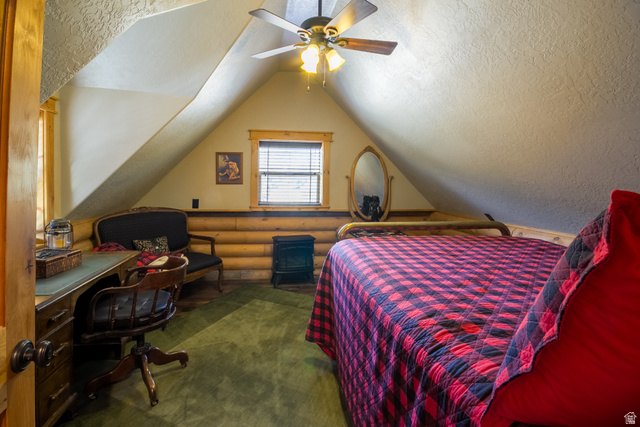 18906 North Canyon Road Whiterocks, UT 84085 - Photo 44 of 65 Bedroom with vaulted ceiling, an office area, a textured ceiling, ceiling fan, and rustic walls