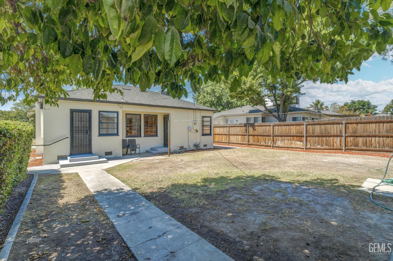 Undisclosed Address Bakersfield, CA 93305 - Photo 27 of 27 a view of a backyard with large trees and wooden fence