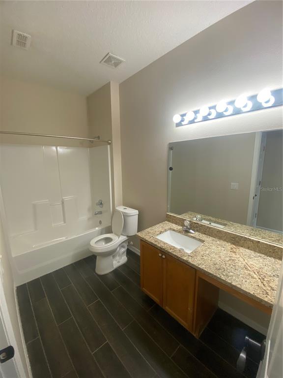 2409 Spring Hollow Loop Wesley Chapel, FL 33544 - Photo 23 of 47 a bathroom with a granite countertop sink a toilet and shower