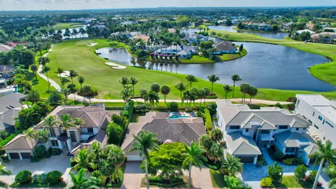 an aerial view of residential houses with outdoor space and lake view