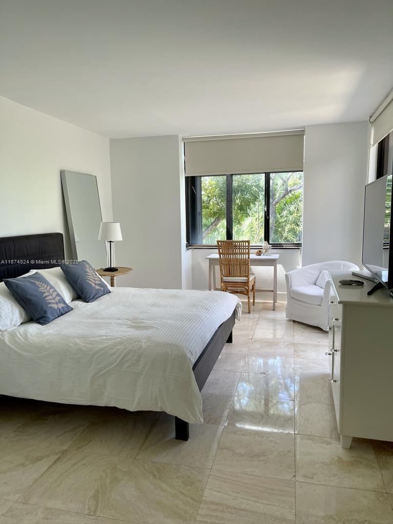 101 Crandon Boulevard, Unit 381 Key Biscayne, FL 33149 - Photo 12 of 16 a bedroom with a bed a large window and walk in closet