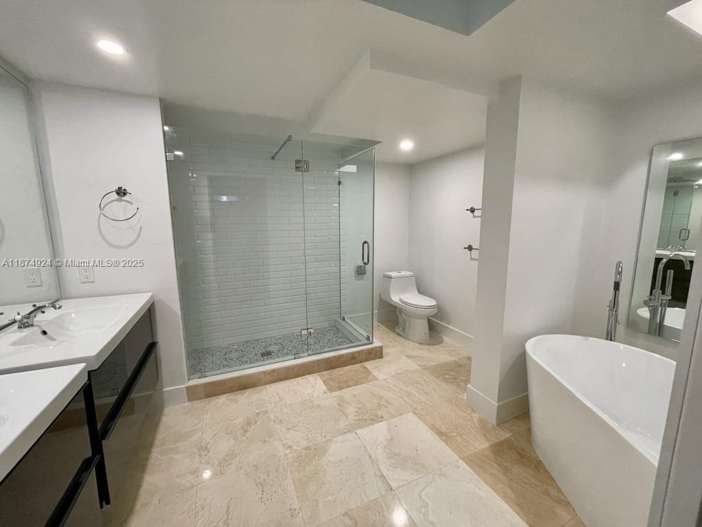 101 Crandon Boulevard, Unit 381 Key Biscayne, FL 33149 - Photo 14 of 16 a bathroom with a double vanity sink toilet and shower