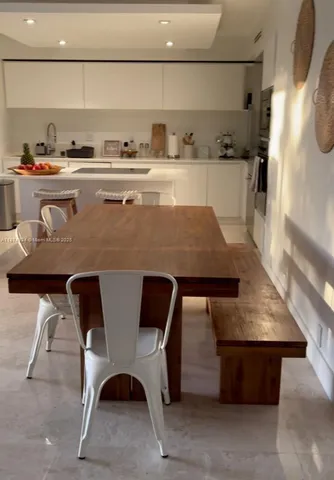 a living room with stainless steel appliances kitchen island granite countertop a sink and a stove with wooden floor