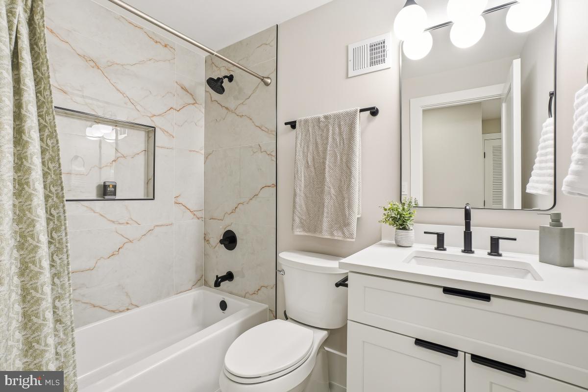 1621 D Street Northeast Washington, DC 20002 - Photo 18 of 31 a bathroom with a sink a toilet a mirror a bathtub and shower