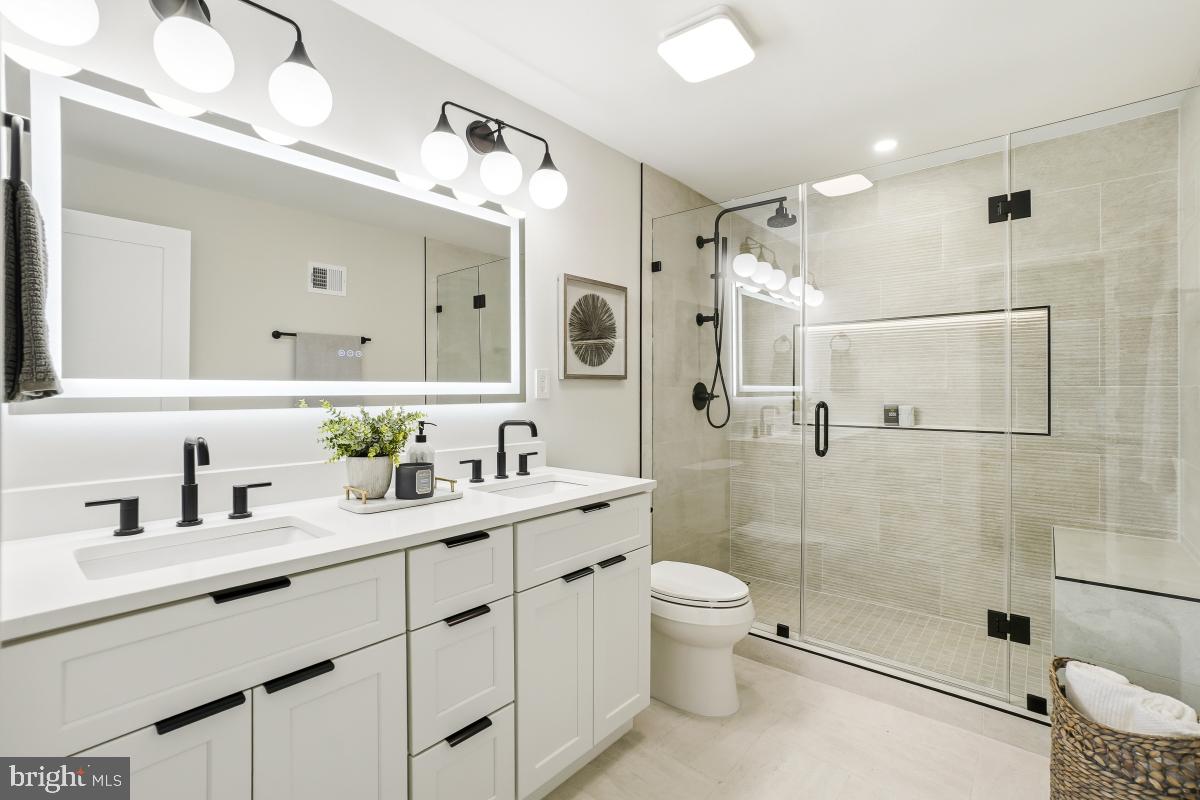1621 D Street Northeast Washington, DC 20002 - Photo 23 of 31 a bathroom with a double vanity sink toilet mirror and shower