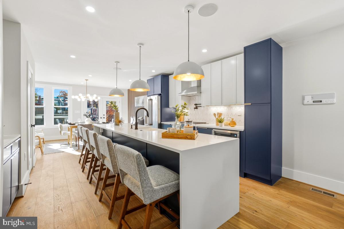 1621 D Street Northeast Washington, DC 20002 - Photo 9 of 31 a kitchen with stainless steel appliances kitchen island granite countertop a table chairs and a wooden floor