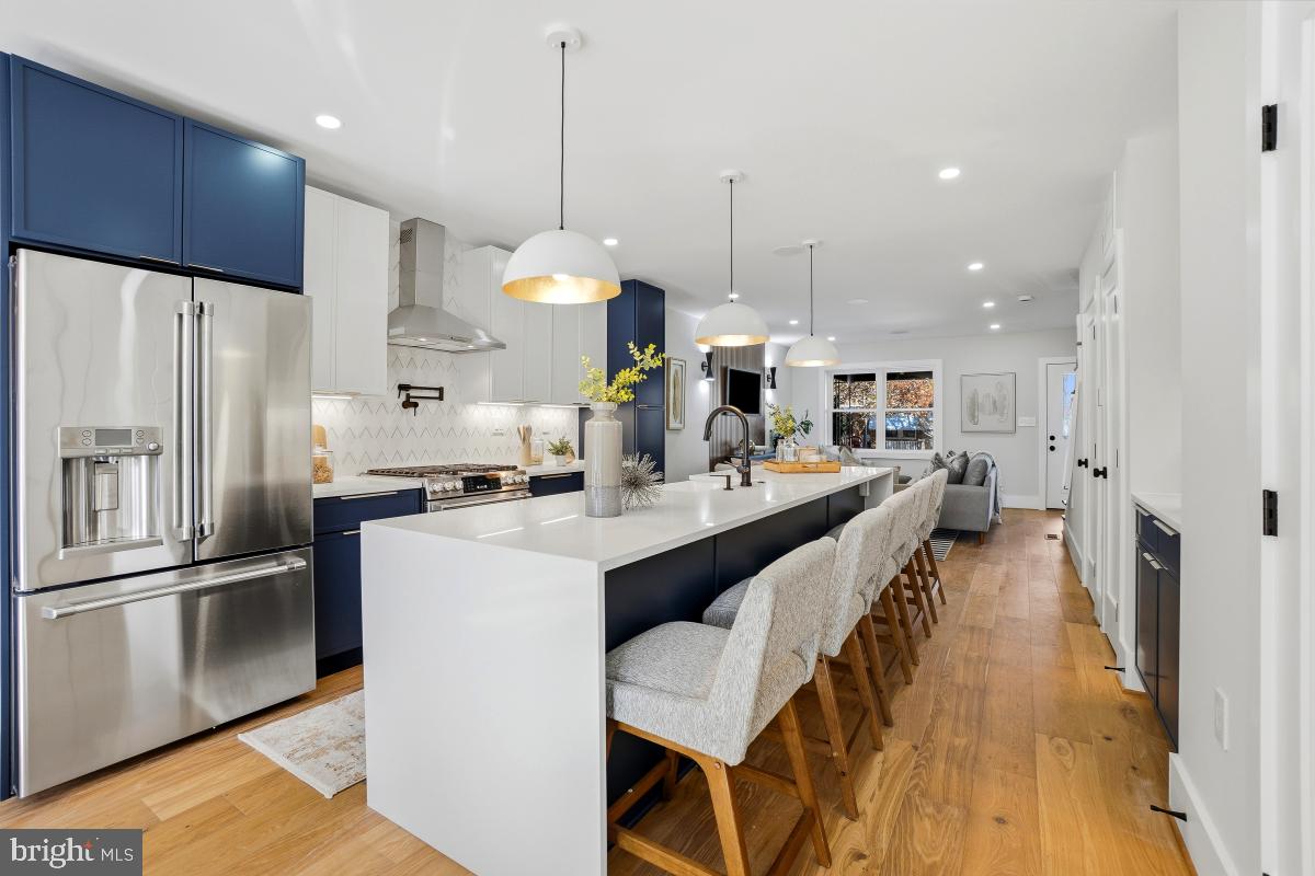 1621 D Street Northeast Washington, DC 20002 - Photo 10 of 31 a kitchen with stainless steel appliances kitchen island granite countertop a refrigerator a oven a sink and a dining table with wooden floor