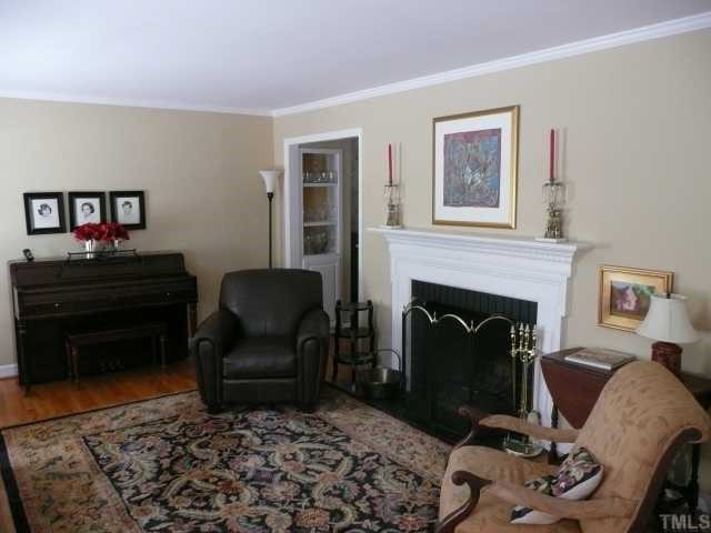 Natural light fills the large living room with fireplace. Note the built-ins between living and dining room.
