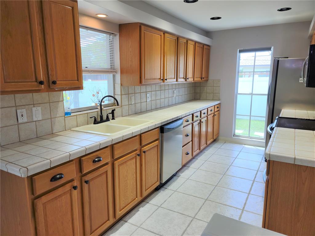 979 Nantucket Road Venice, FL 34293 - Photo 12 of 34 a kitchen with stainless steel appliances granite countertop a sink stove and cabinets