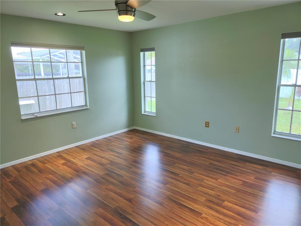 979 Nantucket Road Venice, FL 34293 - Photo 19 of 34 an empty room with wooden floor and windows
