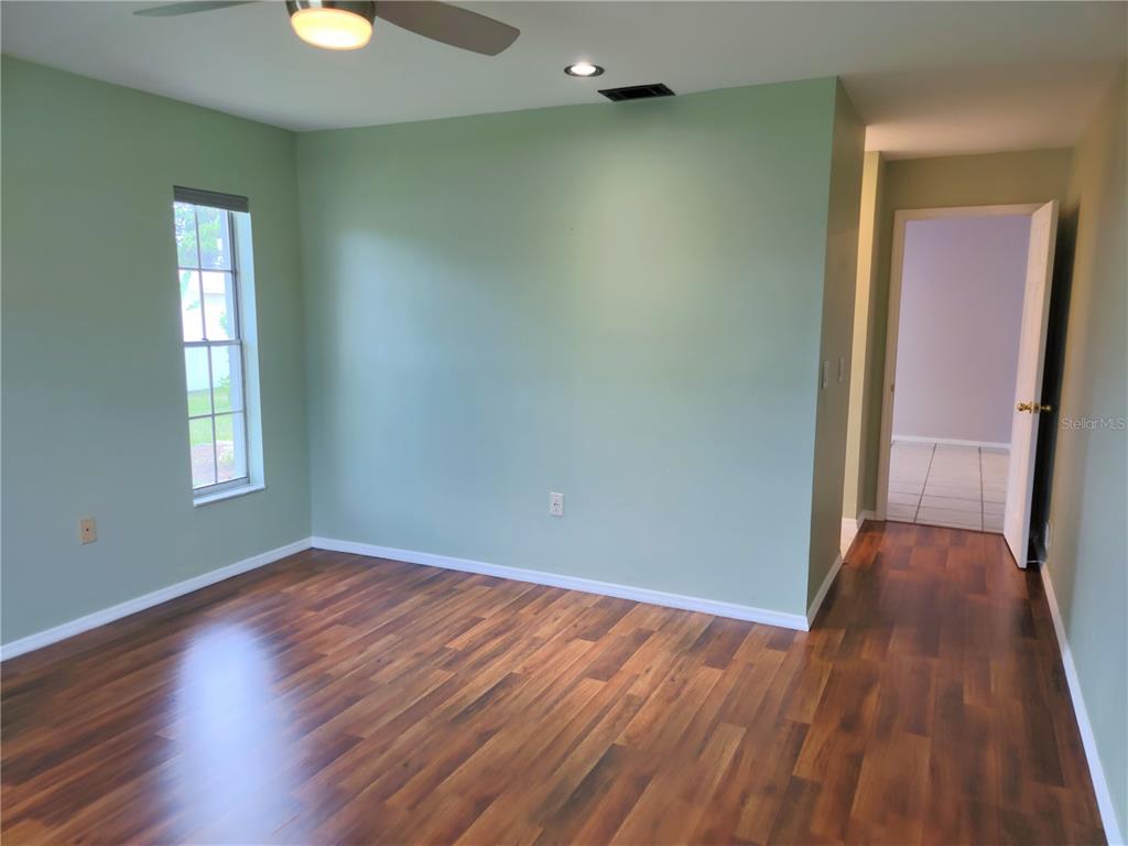979 Nantucket Road Venice, FL 34293 - Photo 21 of 34 an empty room with wooden floor and windows