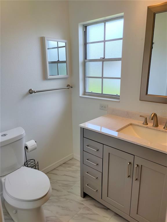979 Nantucket Road Venice, FL 34293 - Photo 24 of 34 a bathroom with a toilet sink and window