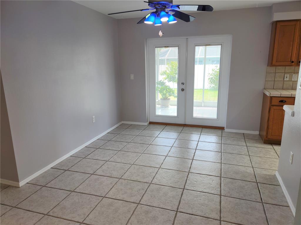 979 Nantucket Road Venice, FL 34293 - Photo 9 of 34 an empty room with windows and chandelier fan