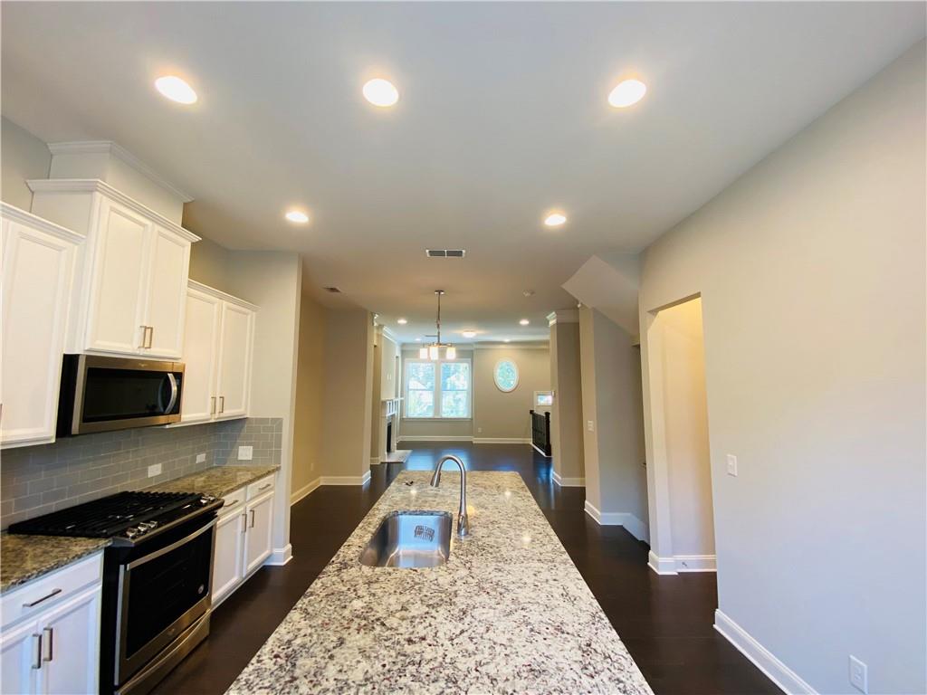 1815 Hislop Lane, Unit 8 Atlanta, GA 30345 - Photo 11 of 38 a large kitchen with kitchen island granite countertop a sink and stainless steel appliances