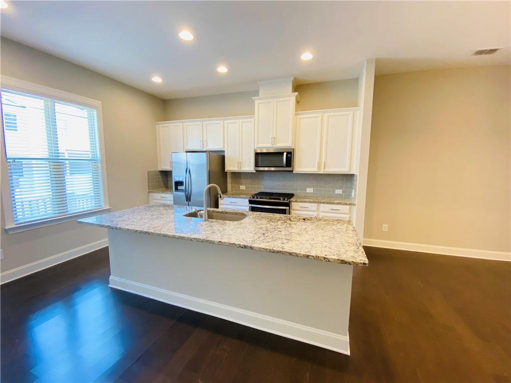 1815 Hislop Lane, Unit 8 Atlanta, GA 30345 - Photo 7 of 38 a large kitchen with stainless steel appliances granite countertop a stove a sink a refrigerator and a microwave