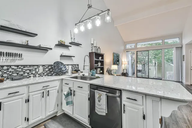 a kitchen with white cabinets and window